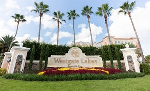 A sign for Westgate Lakes Resort & Spa with a landscaped foreground and palm trees. - Studio Near Disney & Universal - Westgate Lakes Resort (Orlando)