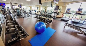 A gym with exercise equipment, a blue mat, and a large blue exercise ball. - Studio Near Disney & Universal - Westgate Lakes Resort (Orlando)