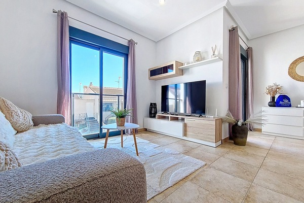 Bright and modern living space in a centrally located 2-bedroom apartment in San Pedro del Pinatar, featuring a cosy lounge, dining area, and access to a private patio.