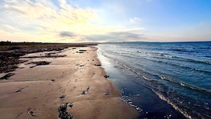 A beach with a wide sandy shore, a calm sea, and a partly cloudy sky. - 4 Star Holiday Home in Vig (Vig)