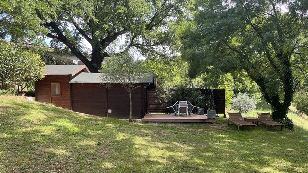 A wooden cabin with a deck, surrounded by trees and grass. - I'm renting a 2-person wooden chalet from April 01 to May 20, 2026. (Salernes)