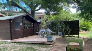 A wooden cabin with a deck, outdoor seating, and potted plants. - I'm renting a 2-person wooden chalet from April 01 to May 20, 2026. (Salernes)