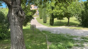 A gravel path leading to a building with a stone facade, surrounded by trees and greenery. - I'm renting a 2-person wooden chalet from April 01 to May 20, 2026. (Salernes)