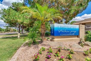 A sign for Lakeshore condominiums with a clear view of the surrounding landscaping and trees.