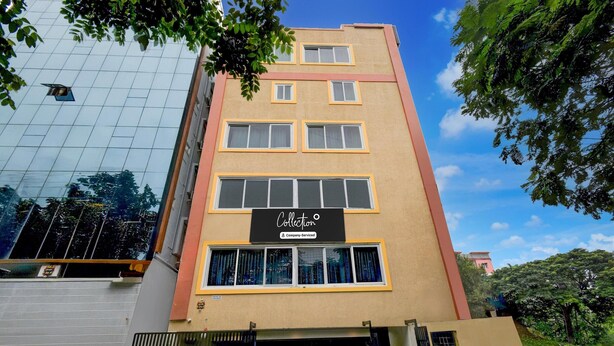 Un edificio a più piani con facciata in vetro, un cartello con la scritta 'Collection' e una scalinata che conduce all'ingresso.