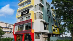 A multi-story building with a sign reading 'TOWNHOUSE Company-Serviced.' - Super Townhouse Aiims Kolkata (Kalyani)