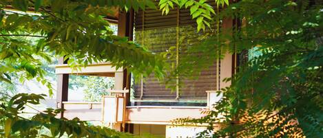 Un edificio japonés tradicional con estructura de madera y una vista a través de una ventana celosía.