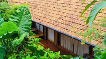 Una terraza de madera con vistas a una habitación que tiene una ventana y una puerta.