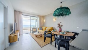 Een moderne woonkamer met een bank, een eettafel, stoelen en een tv-meubel.