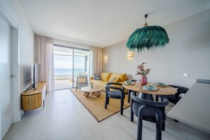 Ein modernes Wohnzimmer mit einer Couch, einem Esstisch, Stühlen und einer TV-Bank.