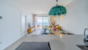 Een moderne keuken met een groot schiereiland, een eetgedeelte met uitzicht, en een woonkamer met een groot raam.