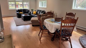 Una sala de estar con una mesa de comedor, sillas, un sofá y una chimenea.
