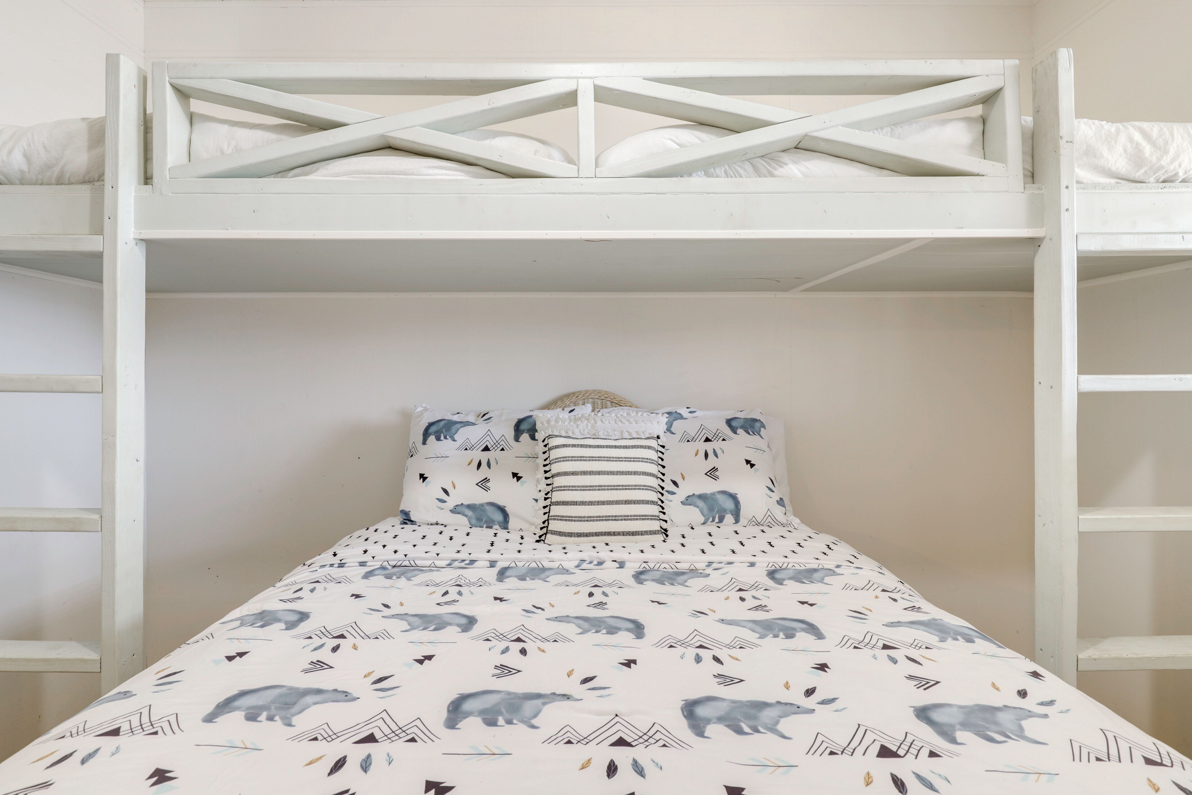 Uma cama beliche com colcha estampada e almofadas combinando.