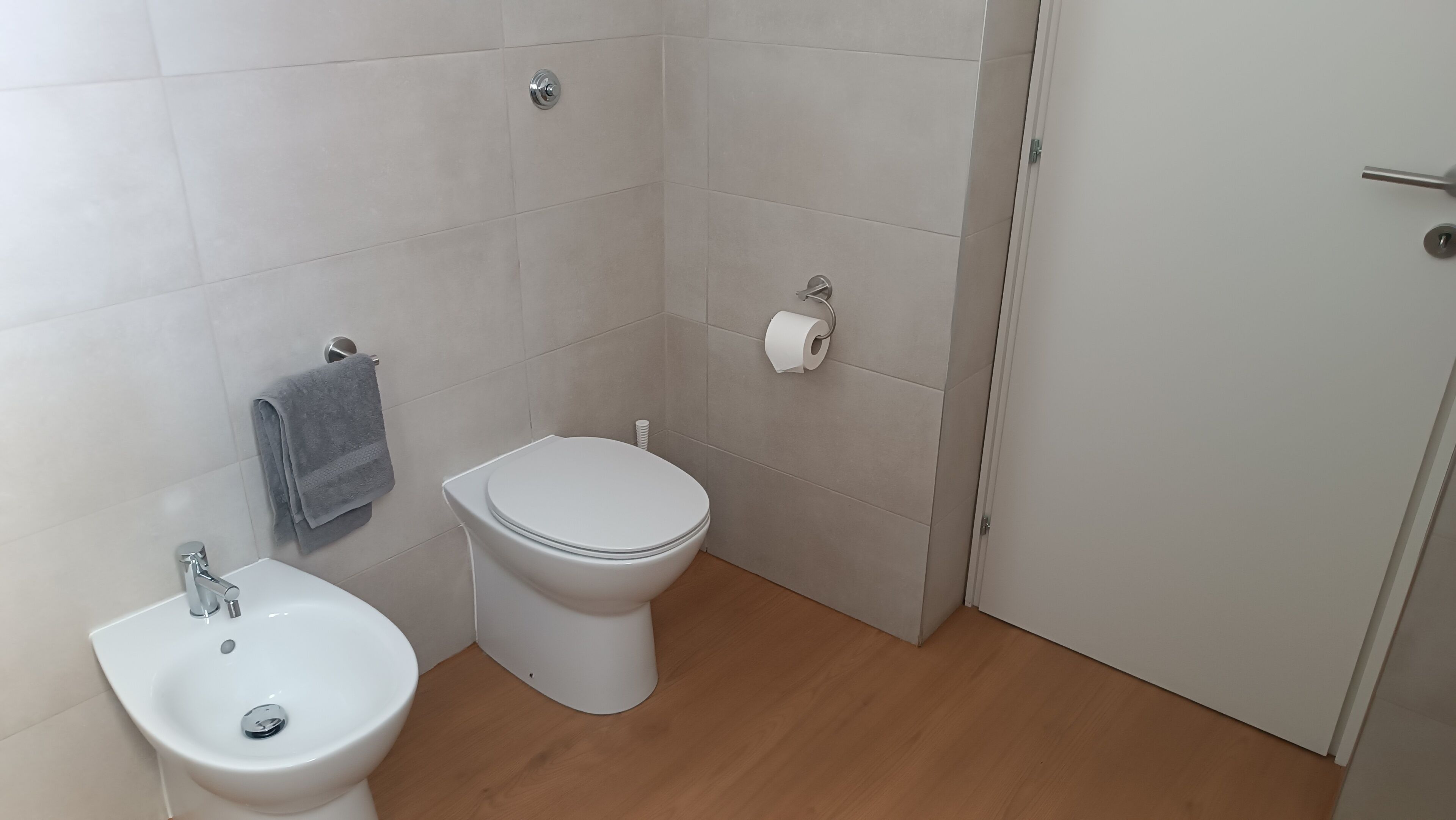 Een badkamer met toilet, bidet en wastafel.