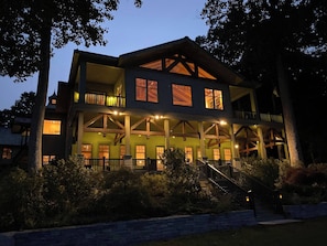 A multi-story building with a balcony, a staircase, and a well-lit entrance.