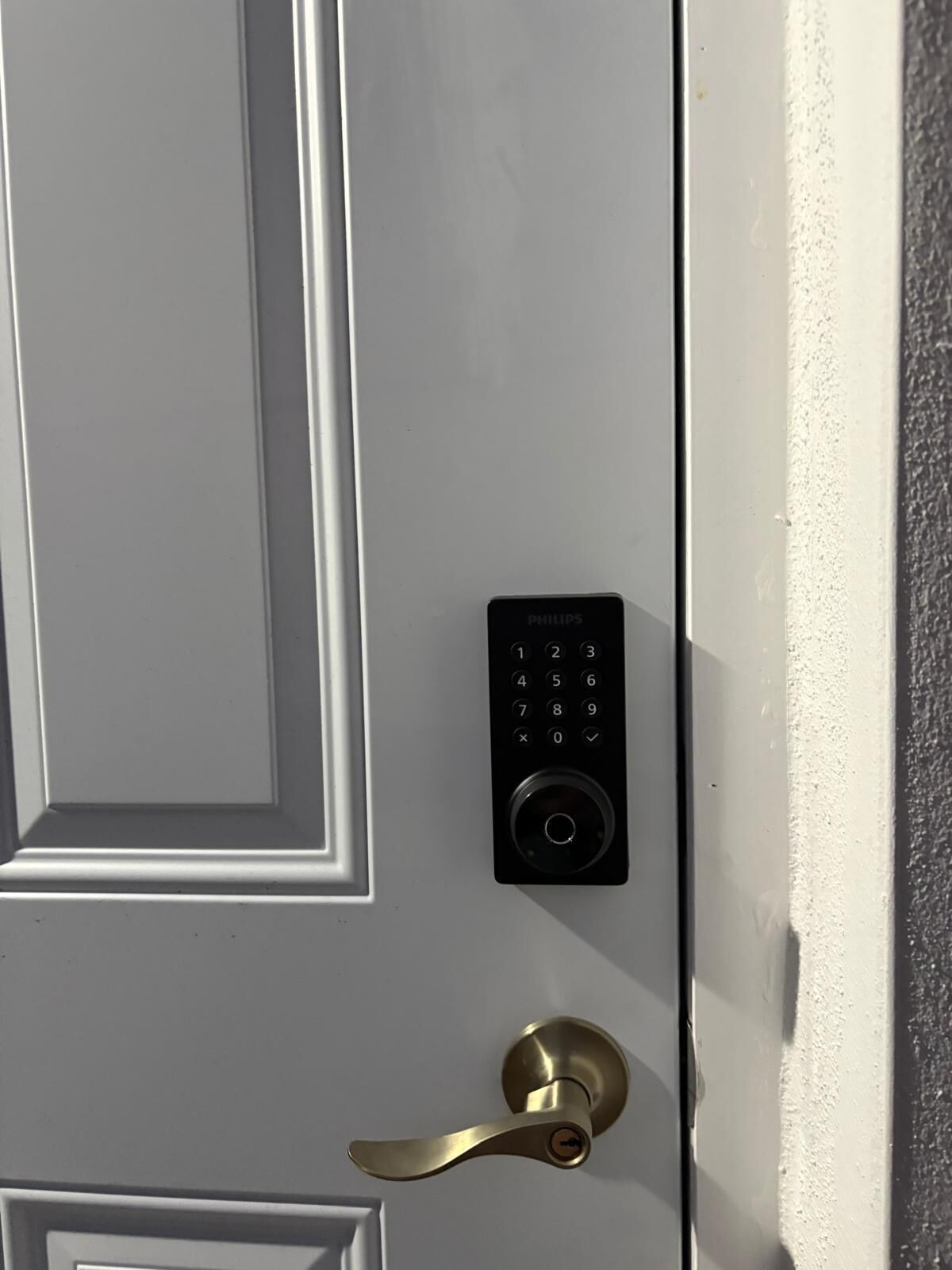 A door with a numeric keypad lock and a brass door handle.