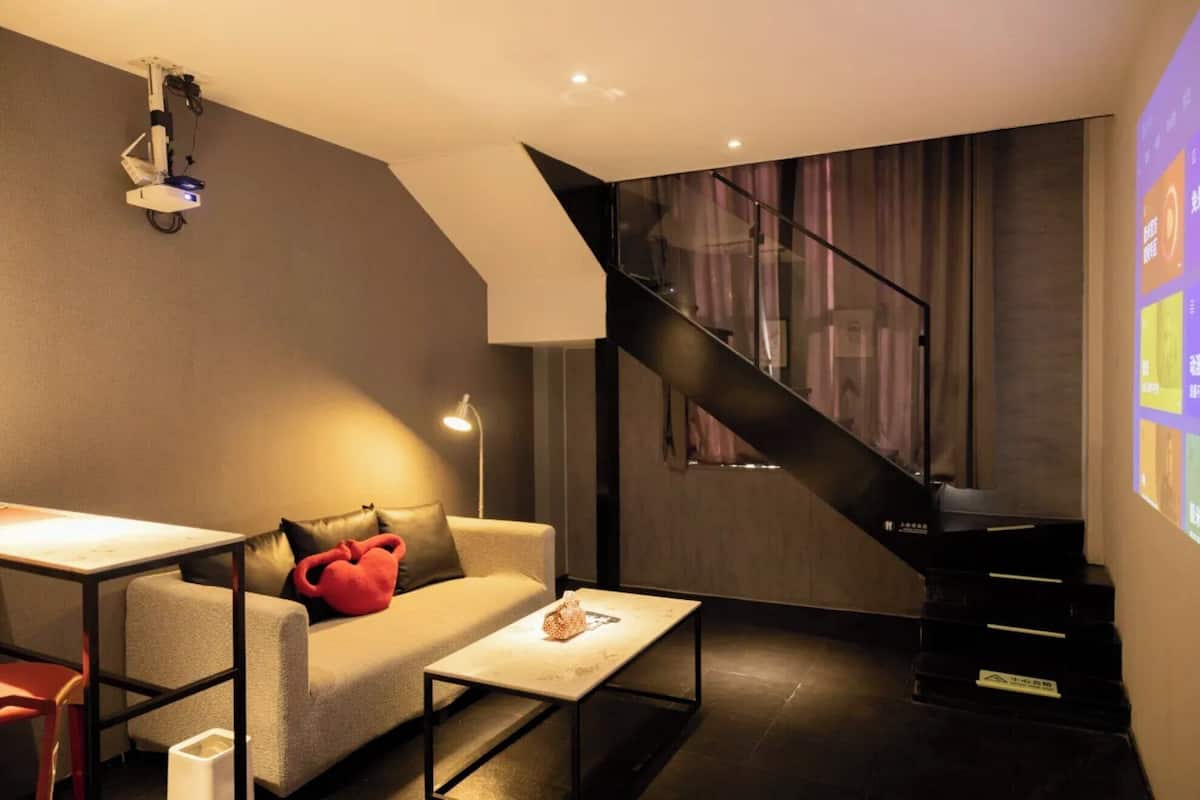 A modern living room with a sofa, coffee table, and a staircase.