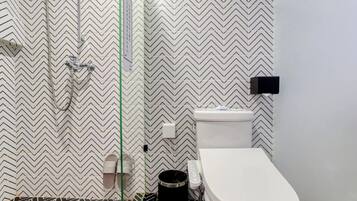 A bathroom with a zigzag patterned wall, a toilet, and a shower area.
