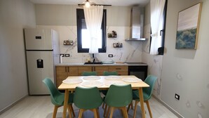 Une cuisine moderne avec une table à manger, des chaises et un réfrigérateur.