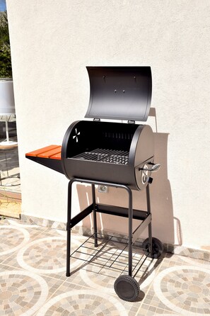 A barbecue grill with a lid open, placed on a tiled patio. - Villa Akdhar - Breakfast - green & bright (Essaouira)