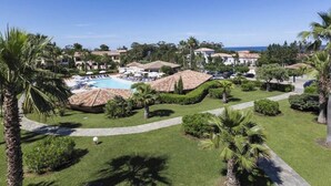 Ett semesterparadis med en swimmingpool, palmer och en fantastisk utsikt över havet.