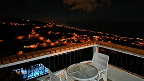 A balcony with a table and chairs overlooking a cityscape at night. - Ocean Heated Pool Jacuzzi View Executive202 (Santa Cruz)