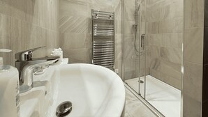 A modern bathroom with a freestanding bathtub, a glass-enclosed shower, and a towel rack. - Beautiful 2 bed Flat in City Centre (Sheffield)