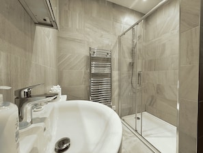 Ein modernes Badezimmer mit einer freistehenden Badewanne, einer gläsernen Duschkabine und einem Handtuchhalter.