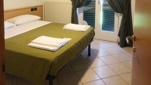 A hotel room with a bed, a ceiling fan, a radiator, and a window with curtains. - R&B Casa Wanda since 1999 (Riva del Garda)