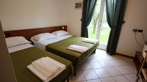 A hotel room with two beds, a wooden headboard, a window with curtains, and a tiled floor. - R&B Casa Wanda since 1999 (Riva del Garda)