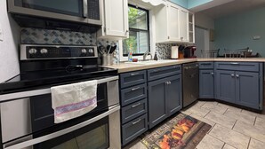 Una cocina equipada con estufa, horno, microondas, lavaplatos y armarios.