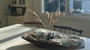 A dining table with a centerpiece of stones, glassware, and dried plants. - 4 Star Holiday Home in Nykobing Sj (Nykobing Sjaelland)