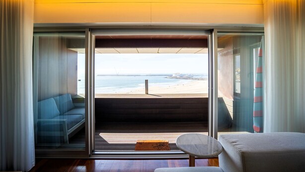 A room with a sliding glass door leading to a balcony with a view of the beach. - Casa Marmite Sea View (Matosinhos)
