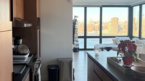 A modern kitchen with a view of a city skyline. - 2-bedroom apartment in Greenpoint Brooklyn with stunning views (Brooklyn)