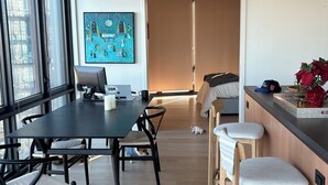 A modern kitchen with a dining area, a large window, and a door leading to another room. - 2-bedroom apartment in Greenpoint Brooklyn with stunning views (Brooklyn)