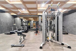 A gym with various exercise machines, a mirrored wall, and a wooden ceiling. - 3 BR Tulum Penthouse Private Pool & Stunning Views, Fast Internet, Work Area (tulum)