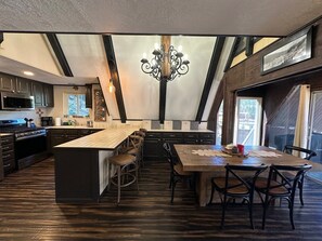 A modern kitchen with a central island, dark cabinetry, and a chandelier. - Rio Rojo in Red River NM (Red River)