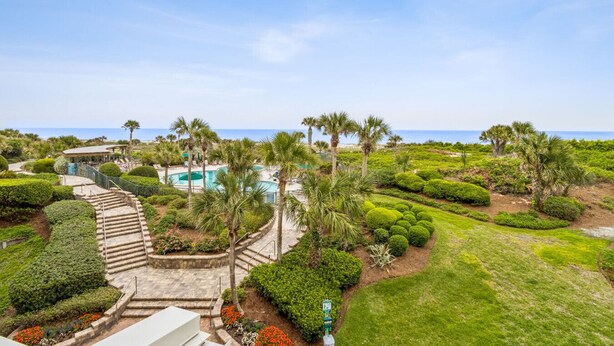 A resort with a pool, palm trees, and a view of the ocean. - Ocean Views from EVERY room! | Oceanfront 2BR Condo | Sleeps 6 | NEW LISTING! | Recently Updated! (Fernandina Beach)