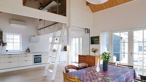 A spacious kitchen with white cabinets, a wooden ceiling, and a dining area with a table set for two. - 4 Star Holiday Home in Korsor (Korsor)