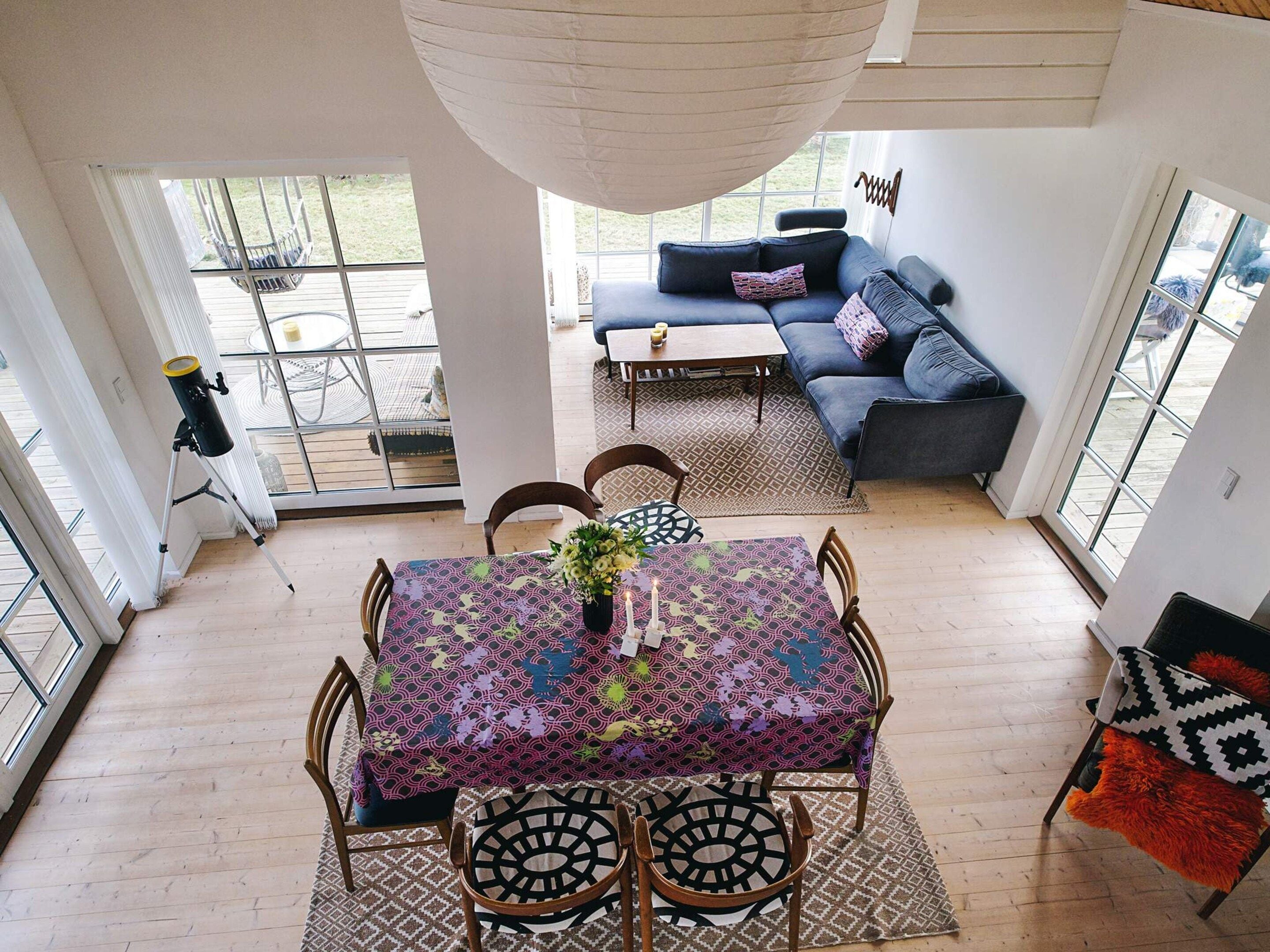 Una habitación amplia con una mesa de comedor, sillas, un sofá y un ventanal grande.