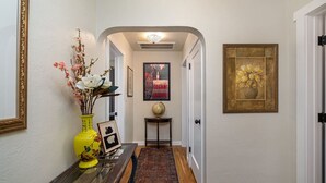 A hallway with a yellow vase, framed picture, and a globe on a side table. - Vintage Vine Retreat w/ Private Studio ~walk Dtwn! (Murphys)