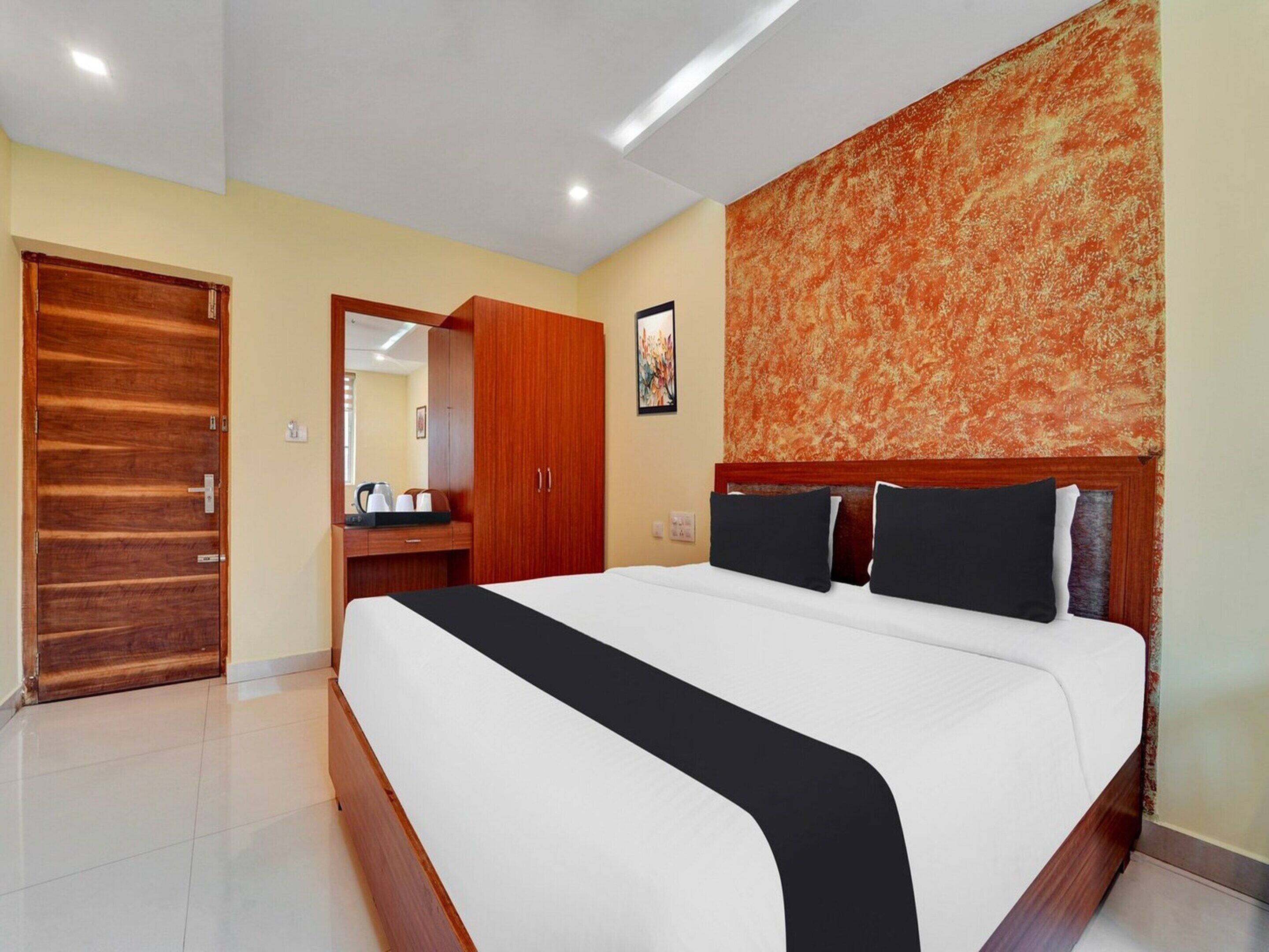 Ein Hotelzimmer mit einem großen Bett, einem Holzschrank und einem Spiegel.
