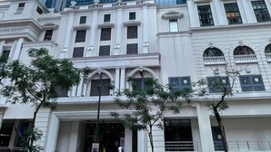 Un immeuble de grande hauteur doté d’une façade moderne en verre et un bâtiment classique avec l’inscription « PARKS SUITES » en dessous.