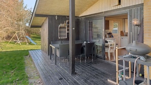 A covered outdoor area with a table and chairs, a barbecue grill, and a slide. - 4 Star Holiday Home in Ronde (Ronde)