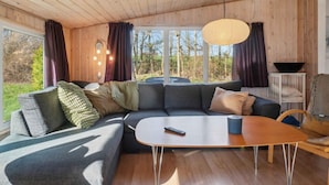 A modern living room with a sectional sofa, a coffee table, and a view of the outdoors. - 4 Star Holiday Home in Ronde (Ronde)