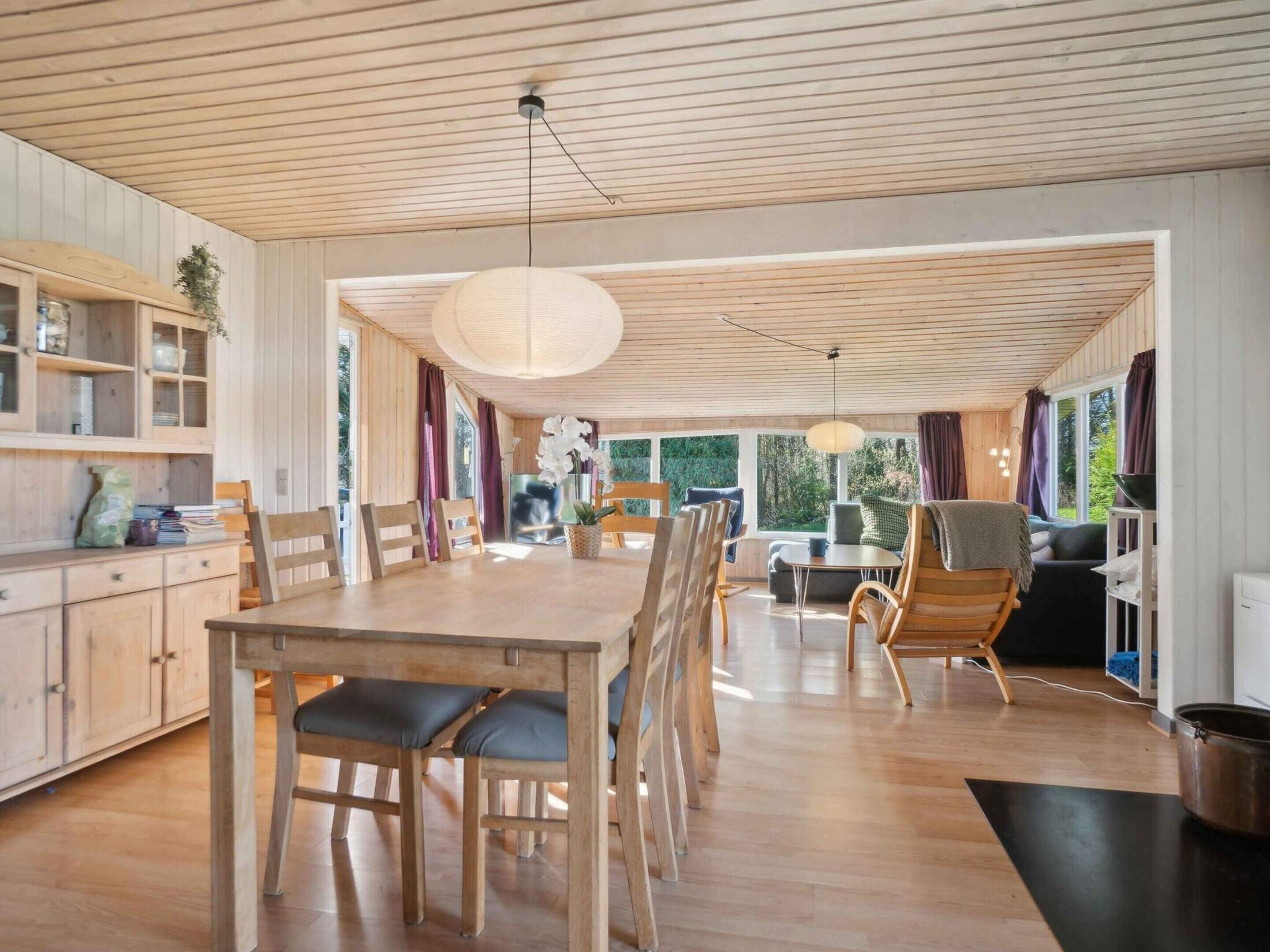 Un intérieur en bois comprenant un coin repas, une cuisine et un espace salon.