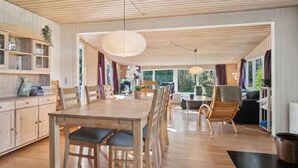 A wooden interior with a dining area, kitchen, and seating space. - 4 Star Holiday Home in Ronde (Ronde)