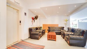 Ein modernes Wohnzimmer mit Ledersofas, einem Holztisch und einem Streifen Teppich.