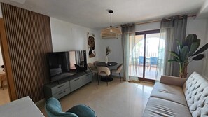 A modern living room with a sofa, TV, dining table, and chairs. - Unique by iulia (Oropesa del Mar)