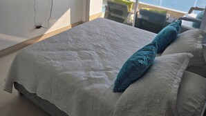 A hotel room with a large bed, a TV mounted on the wall, and a balcony with a view of the sea. - Palmetto Sunset Ocean Front Cartagena Laguito 2904 (Cartagena)